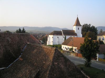 Morgonsolen skiner på den ungerska kyrkan i Albesti (tyska: Weisskirch bei Schässburg), sedd från "Ljusets hus".
